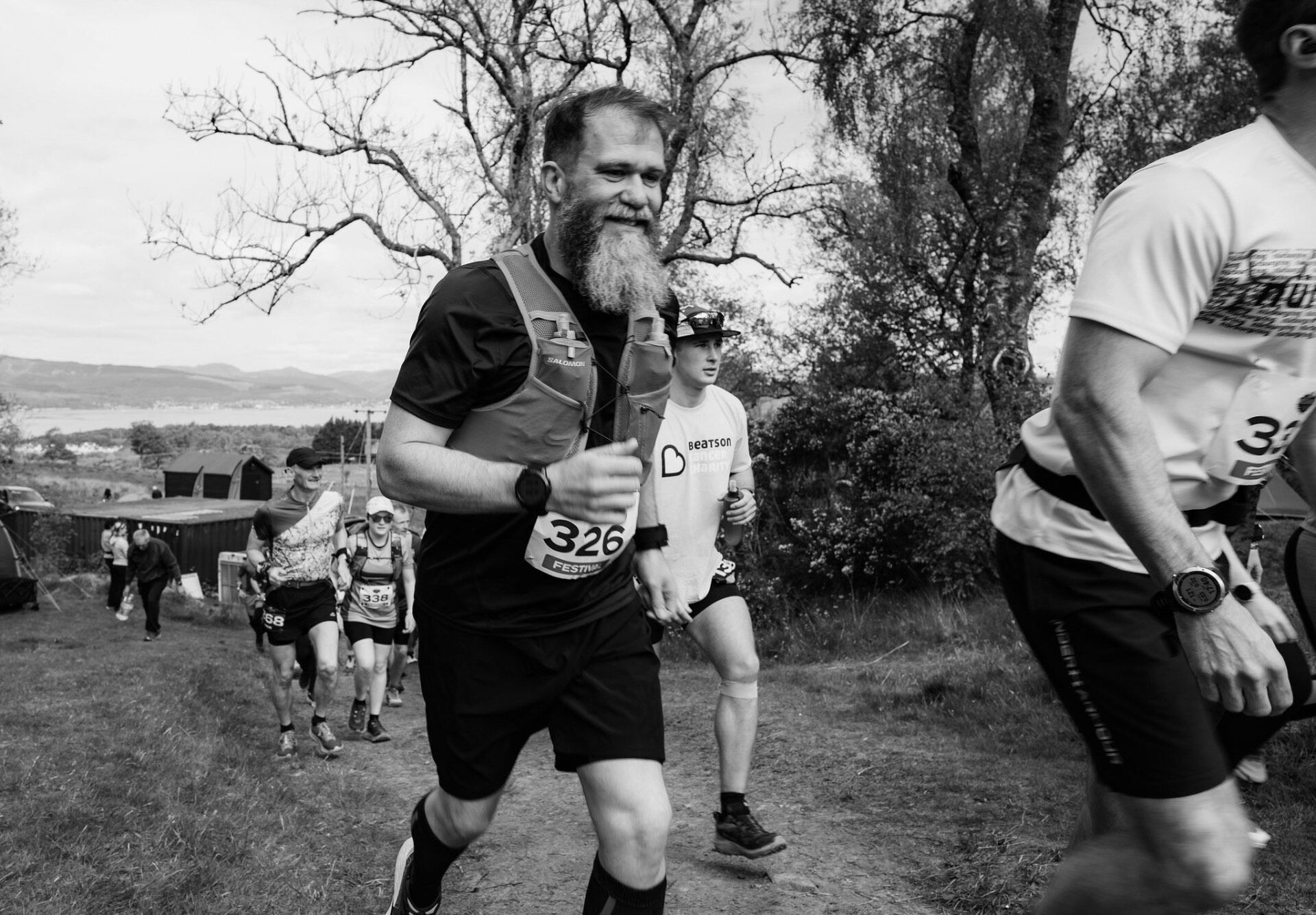Bearded runner with race vest climbing past the firth