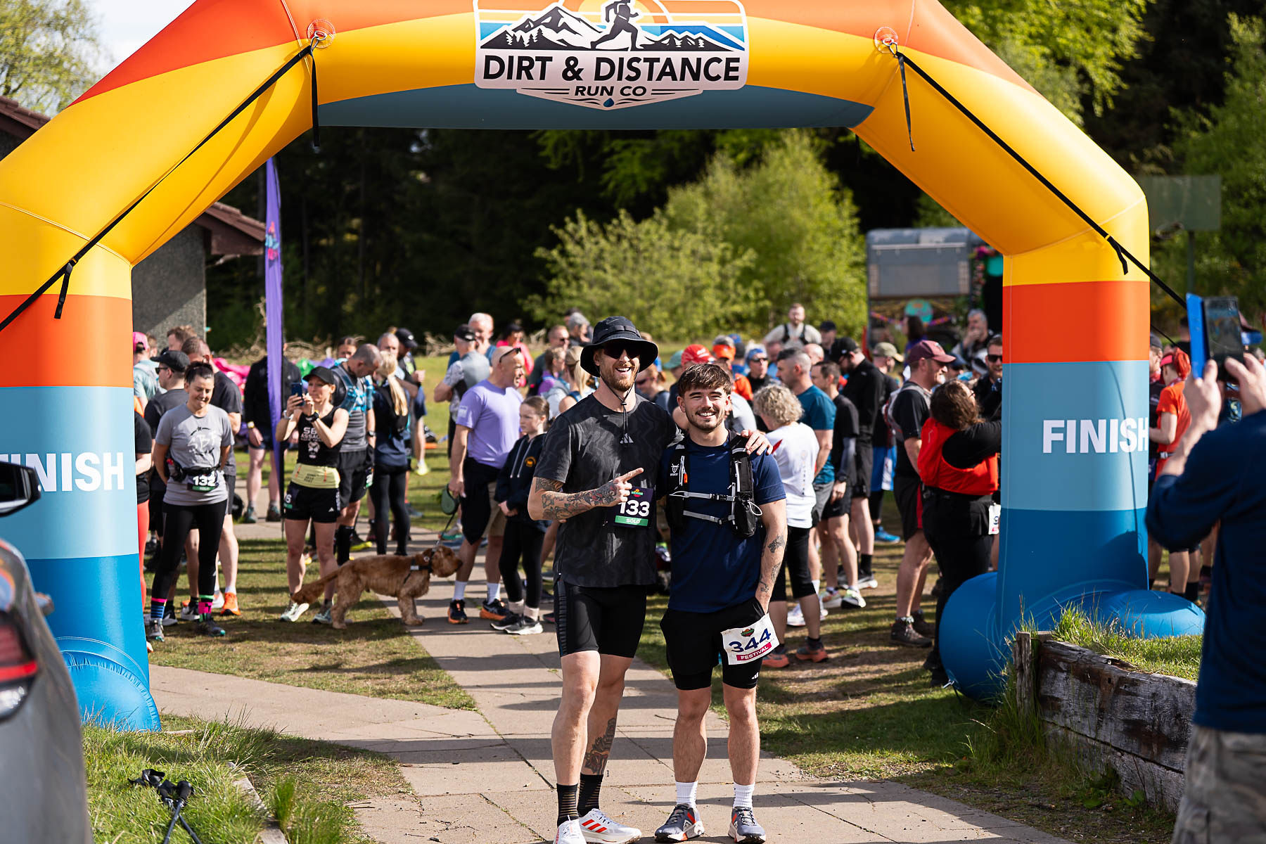 Two runners posing under the finish arch