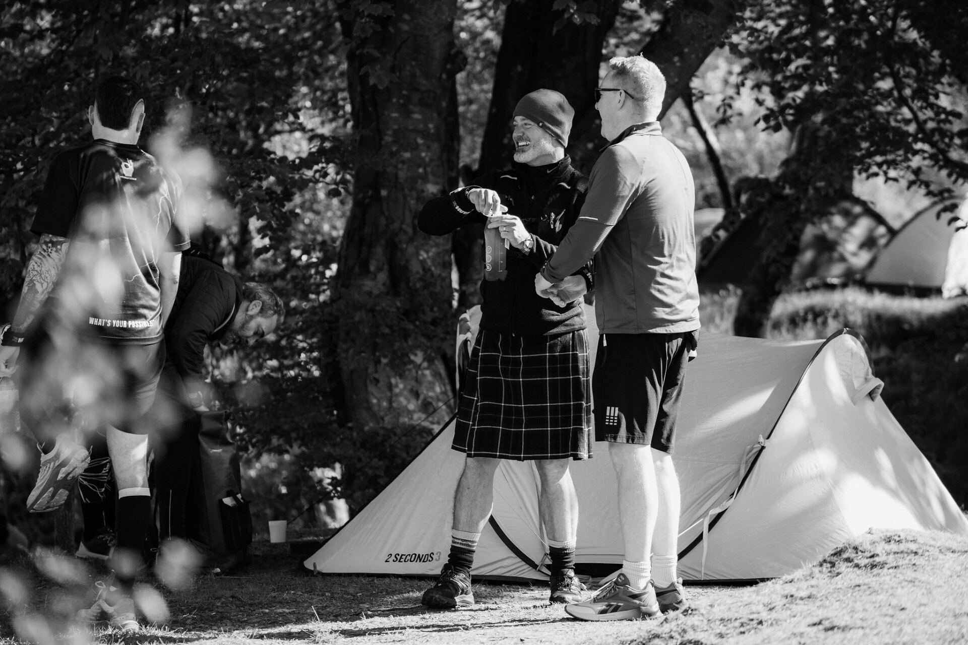 Runners laughing in a kilt at the campsite after the race