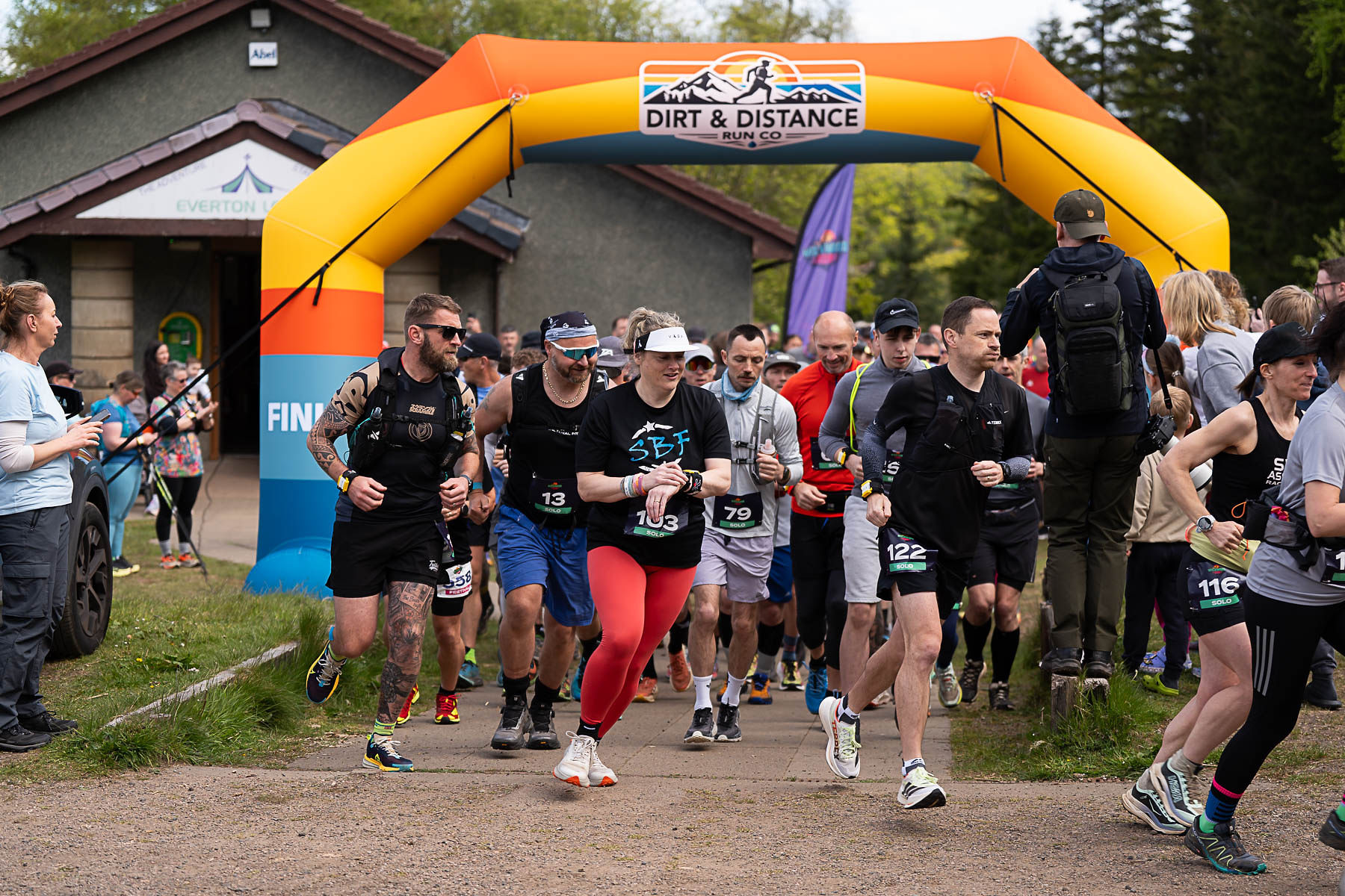 Pack of runners launching under the start arch
