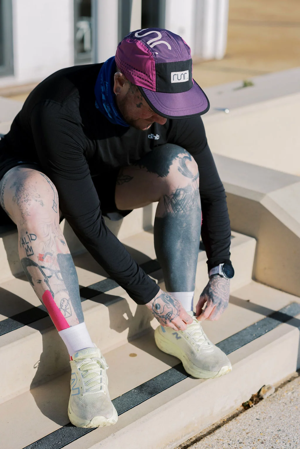 Runner in a purple Runr cap lacing up before a run