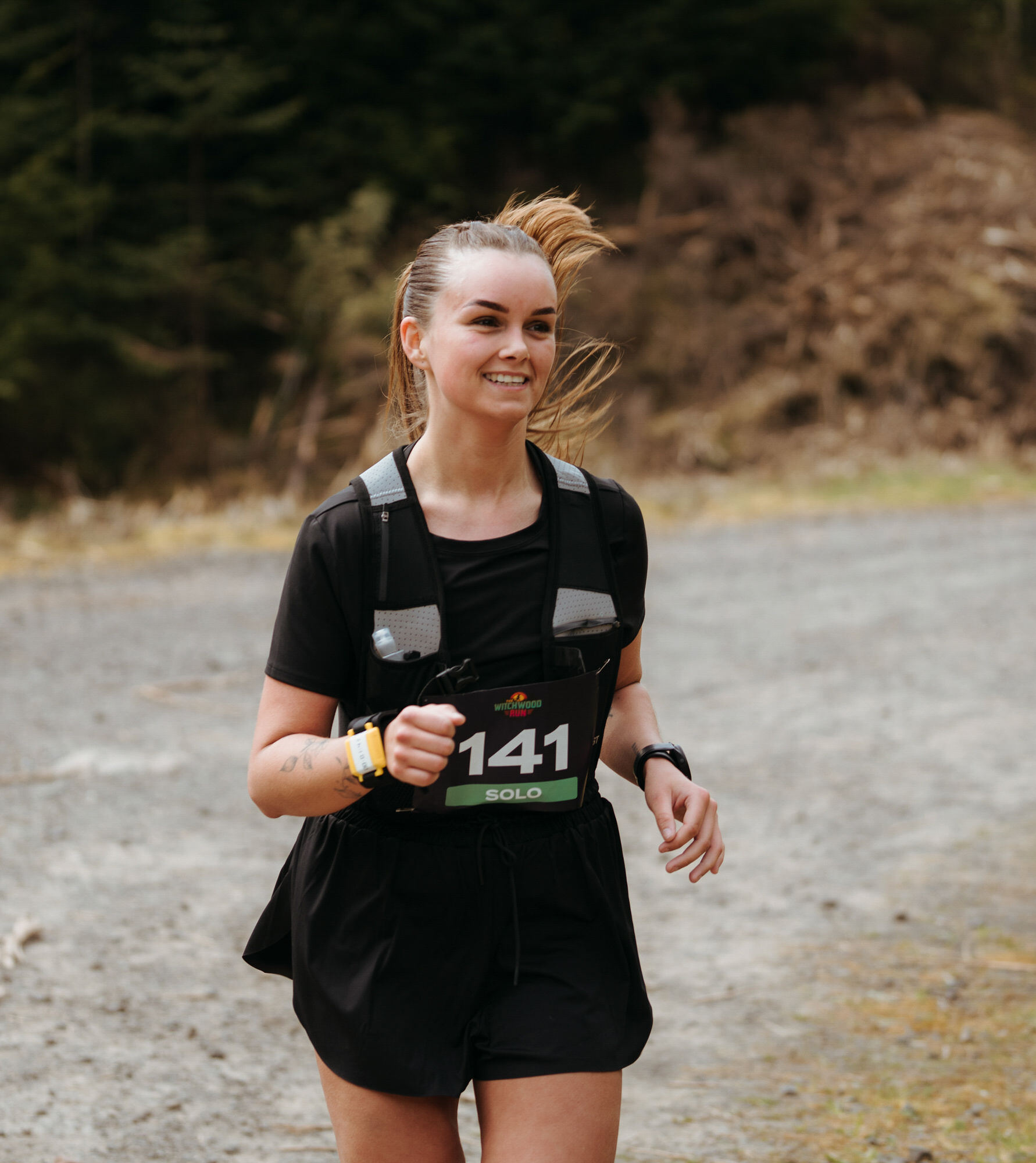 Solo runner number 141 smiling on the gravel track