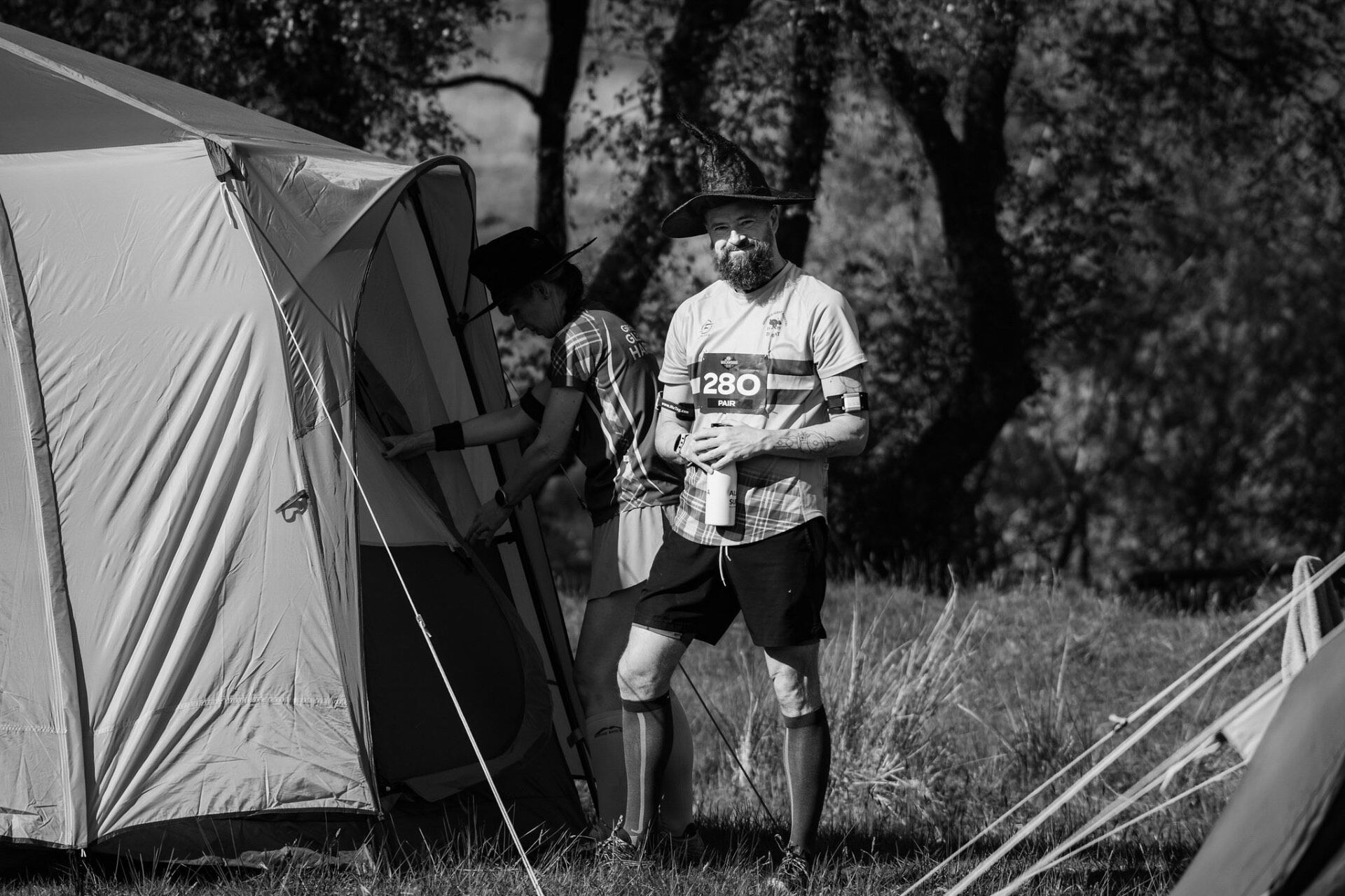 Runner in a witch hat by his tent at race camp