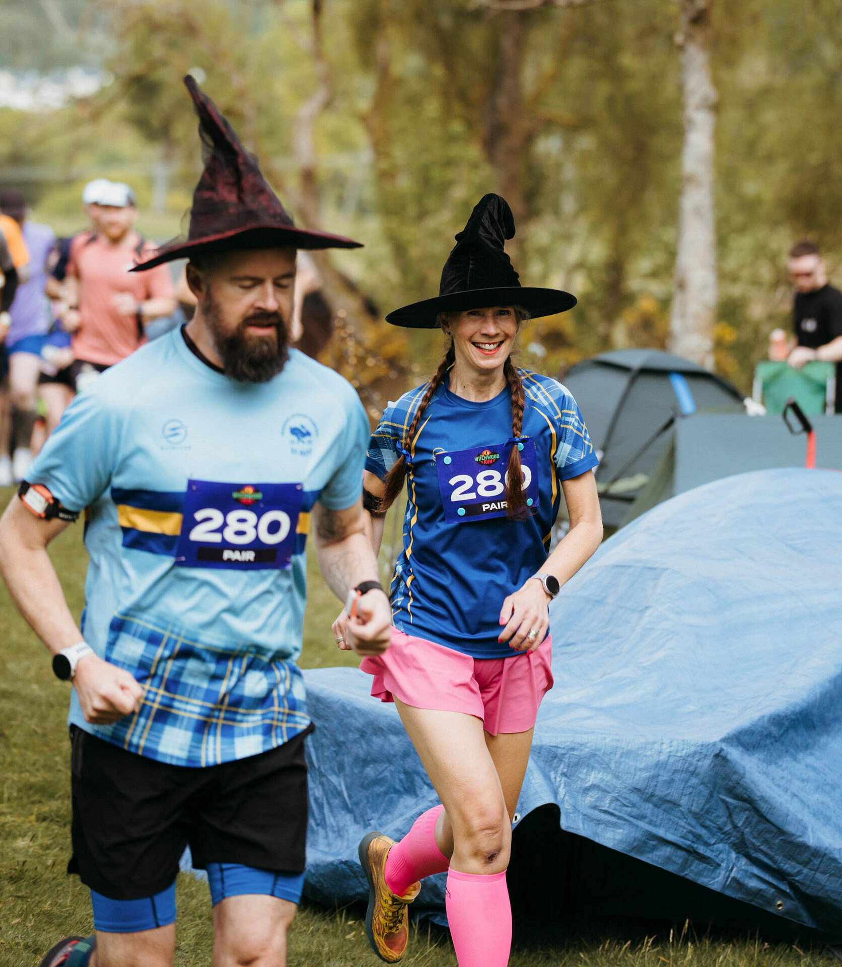 Pair of runners in witch hats and tartan jerseys at race camp