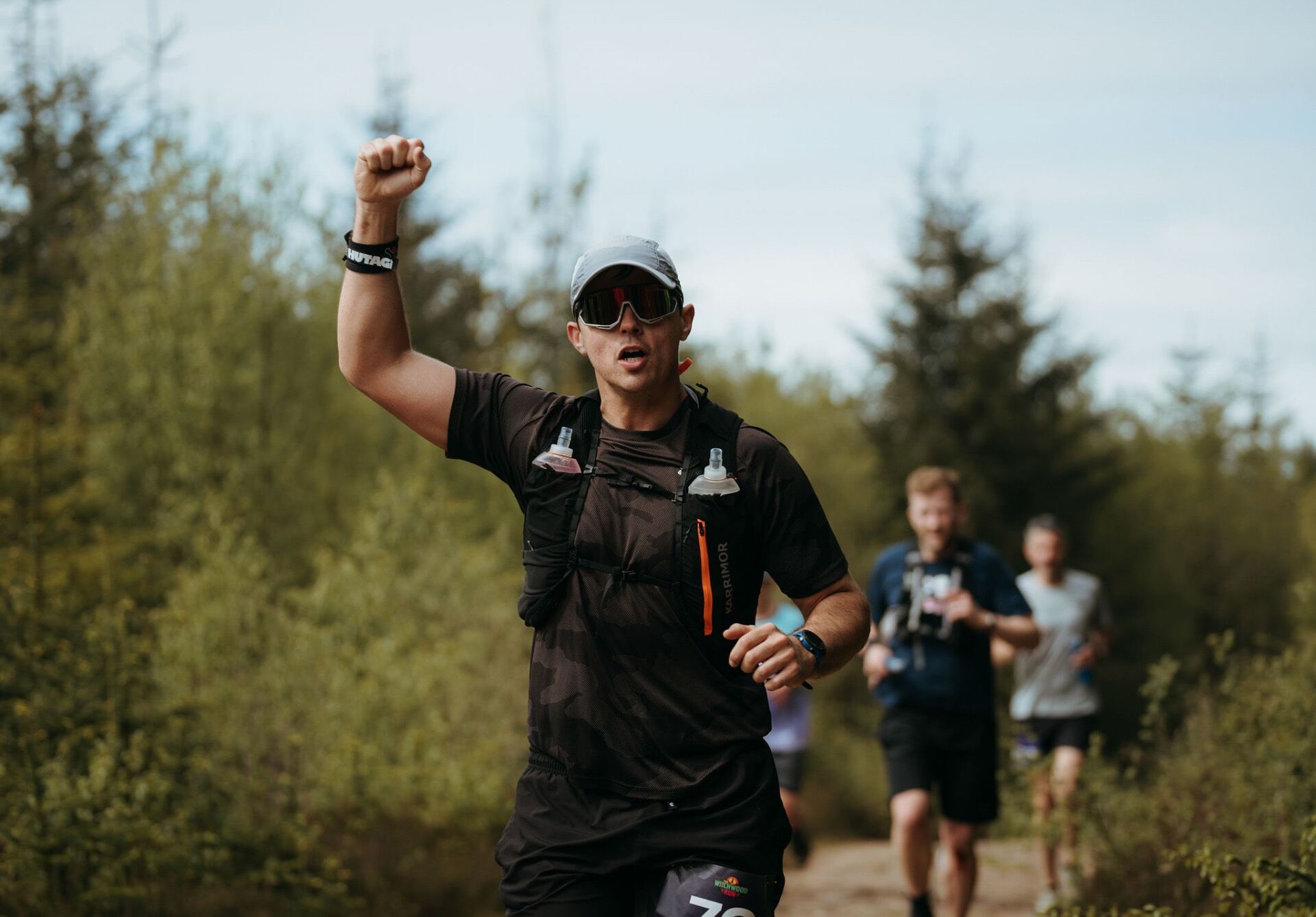 Runner punching the air in celebration on the trail